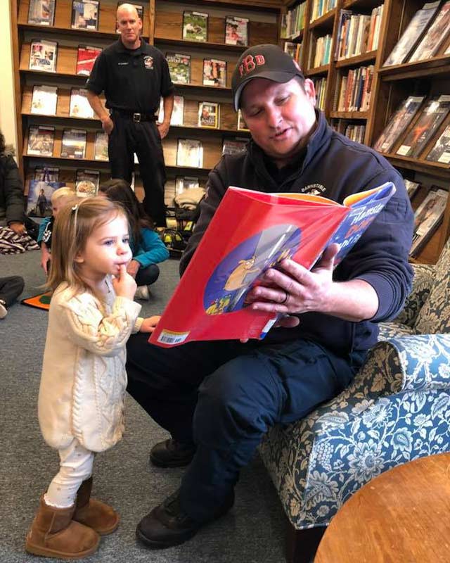 a father reading to his daughter in the library