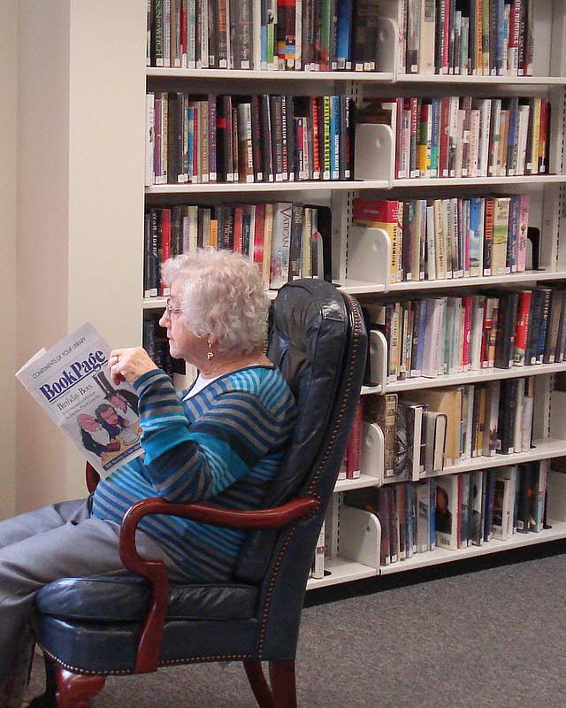 older woman reading and enjoying a book